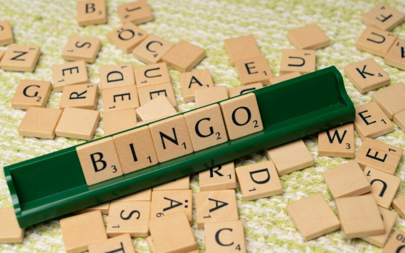 Wooden Scrabble tiles arranged to spell 'BINGO' on a green rack.